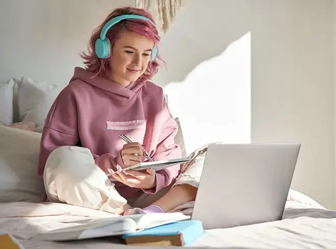 young woman studying in bed